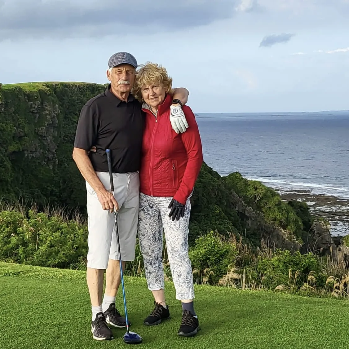 Golfový pár na útesu nad mořem